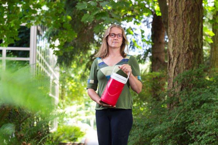 Heather Buckley-wastewater samples on way to lab for testing-UVic Photo Civil engineering researcher Heather Buckley holds a container of wastewater samples on the way to the UVic lab for analysis, part of a project collecting, managing and reporting data from wastewater plants.
