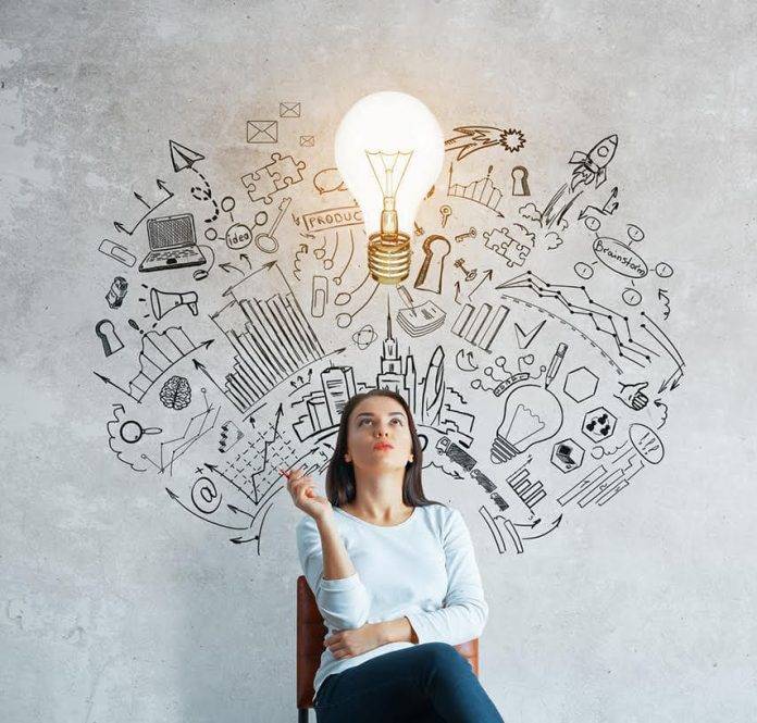 Thoughtful young woman sitting in concrete interior with creative business sketch and shadow. Leadership concept