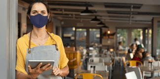 Photo of masked woman at a restaurant.