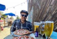 Man eating pizza at an outdoor eatery in Victoria BC