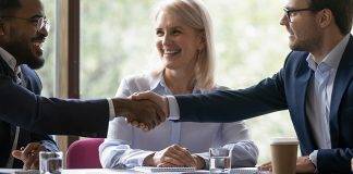 Happy diverse business partners shaking hands