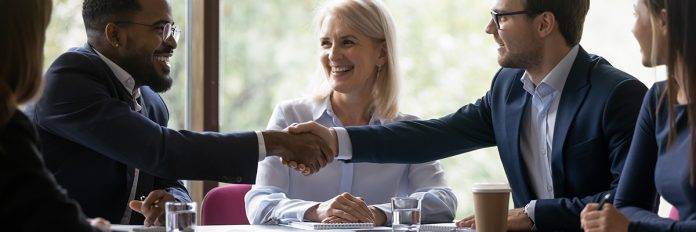 Happy diverse business partners shaking hands