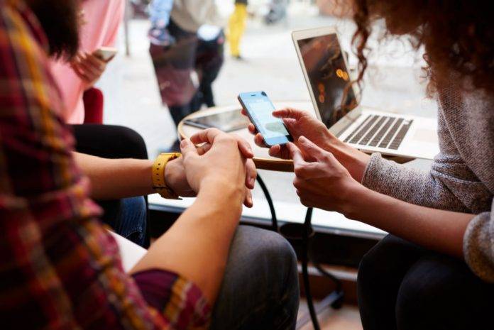 close up of two people looking at a cell phone