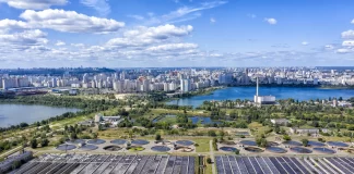 Aerial view of wastewater treatment plant in the foreground of coastal city skyline - Photo by savantermedia, AdobeStock