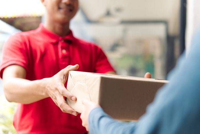delivery man handing package to customer