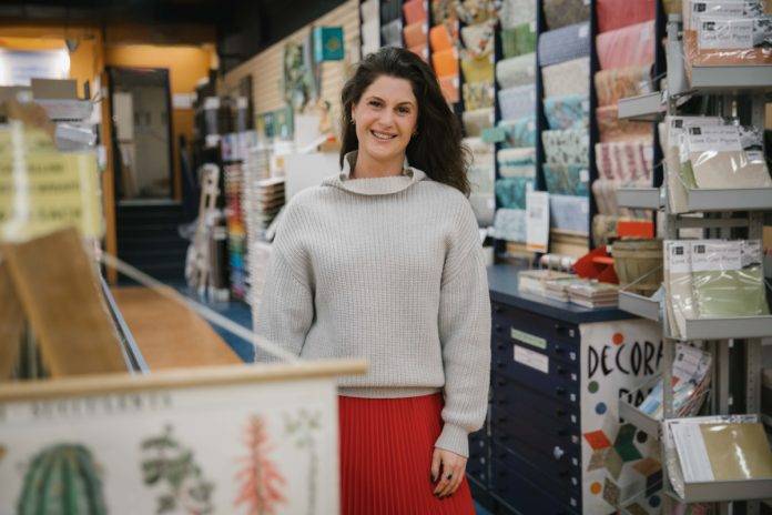Caitlin McKenzie, President & CEO of Monk Office stands inside their newly acquired business, Island Blue Art & Framing.