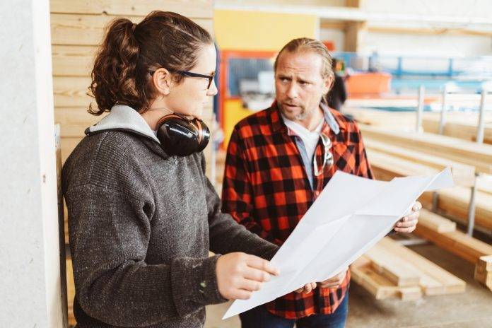 Man and woman on construction site discussing project