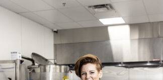 Operations manager Kira Selah is surrounded by Kitchen Connect’s gleaming stainless processing equipment. The commissary is equipped to produce everything from granola to hummus. Photo: Jeffrey Bosdet