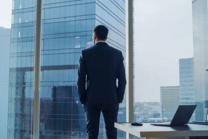 values-based leadership framework Businessman gazing out window