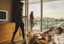 Love is in the Air … and in cash registers, too. Couple enjoying a scenic hotel view of Victoria's Inner Harbour