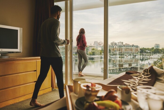 Couple enjoying a scenic hotel view of Victoria's Inner Harbour
